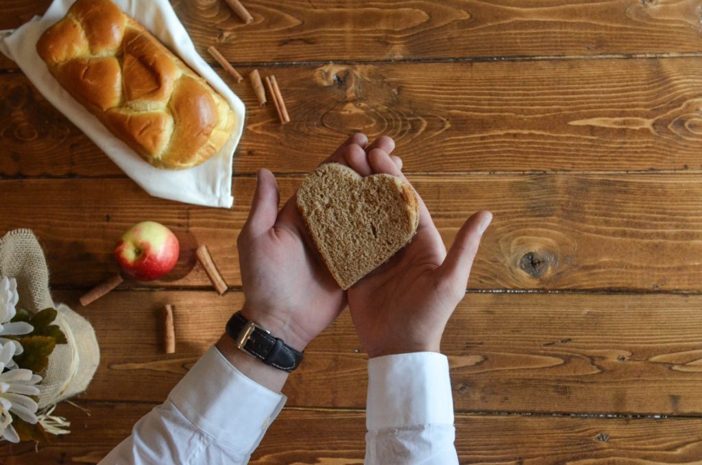 person holding heart shaped bread over table